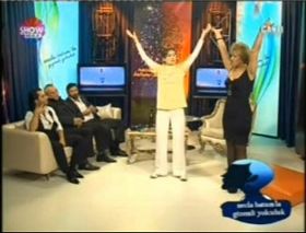 节目主持人（右）在向法轮功学员现场学功