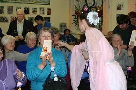 欣赏了法轮功学表演的莲花舞，老人们高兴地接过法轮大法简介和精美的纸莲花