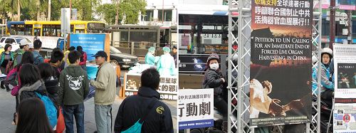 图2-3：“中共活摘法轮功学员器官”模拟演示行动剧吸引车上乘客、摩托车骑士以及熙来攘往的民众聚焦注目。