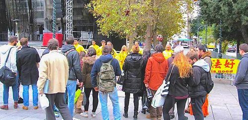 图1-2：二零一五年十二月十一日，希腊法轮功学员在市中心宪法广场上介绍功法，征签诉江
