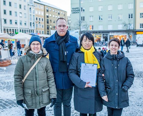 '图6：帕西（Pasi ）先生（左二）和他的女友（右一），在反迫害征签簿上签名并和学员们合影留念，帕西（Pasi）先生还用中文向法轮功学员祝贺新年好！'