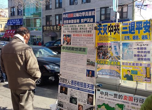 '图1～3：大年初二，法轮功学员们在热闹的布碌仑街上向民众传递真相，很多华人民众驻足阅读真相展板'