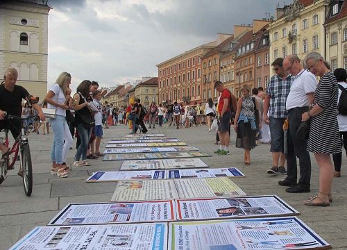 '图9：波兰市民游客观看法轮功真相展板'