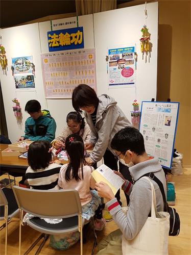 '图8：在展位前仔细阅读法轮功资料的男子'