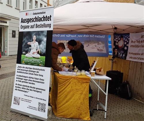 '图5：法轮功学员在海德堡主街与剧院大道交汇处举办活动，民众签名声援。'