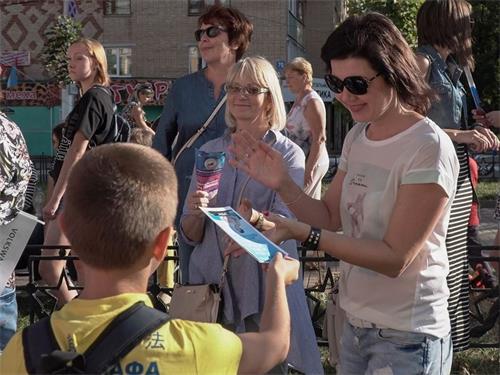 '图5～7：观众接过法轮功资料认真阅读'