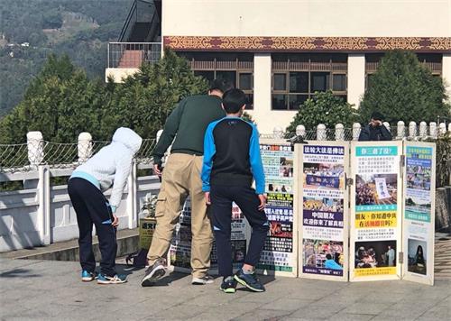 '图2～3：游客在真相展板前驻足观看。'