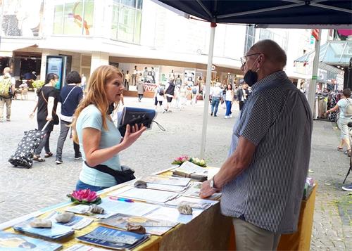 '图4：克劳迪娅和一位法轮功学员交谈'