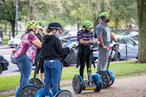 '图5～6：游客从法轮功学员手中接过真相材料。'