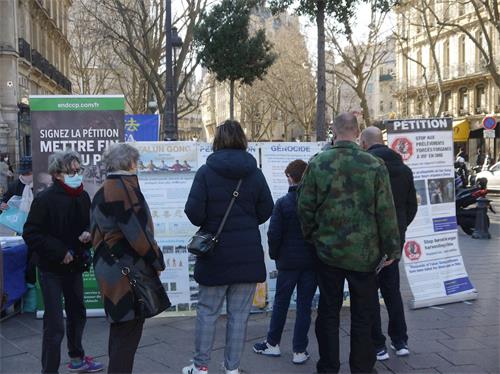 '图1～2：二月二十七日下午，法轮功学员在巴黎圣米歇尔广场（Place Saint Michel）进行了讲真相和征签的活动'