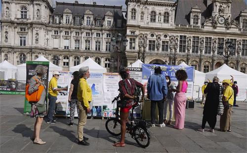 '图2：在巴黎市政厅广场，人们在观看展板，向法轮功学员了解真相'