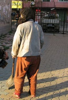 '图：精神失常的张菊贤在街上打扫卫生'